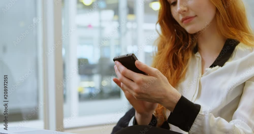Female executive using mobile phone in office 4k