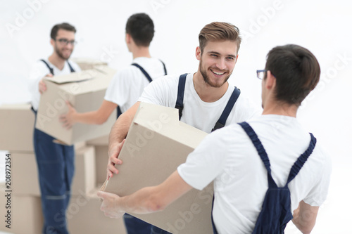 Portrait of movers holding box smiling isolated on white backgro