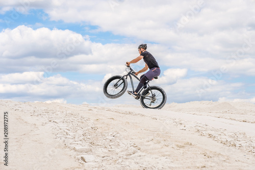 Training a bicyclist in a chalky quarry. A brutal man on a fat bike.