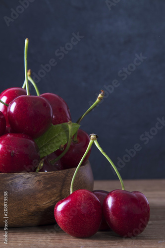 natural cherries piled on rustic wood bottom