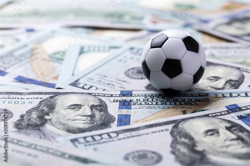 Fototapet Soccer ball on dollar banknotes