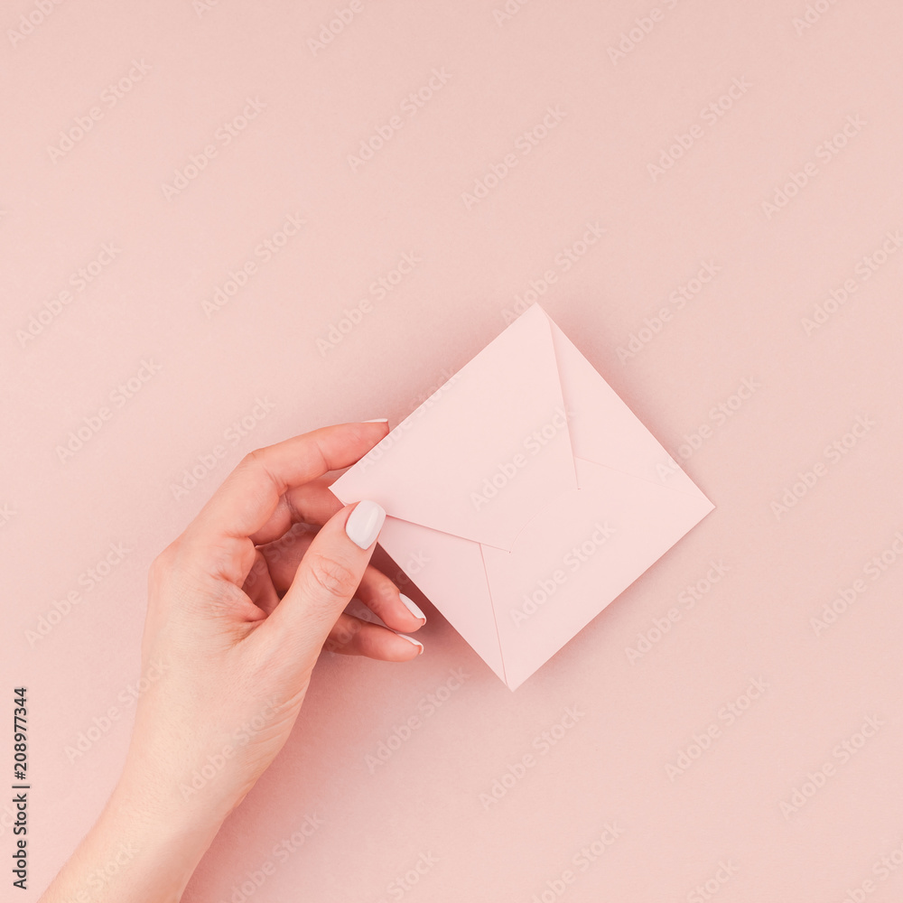Woman hand holding small pink love letter