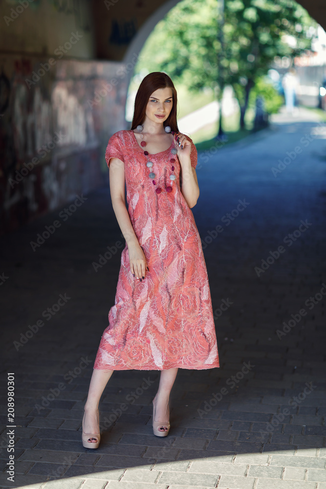 Young stylish girl posing in seamless dress made of merino wool. Model shows designer clothes Young stylish girl posing in seamless dress made of merino wool. Model shows designer clothes