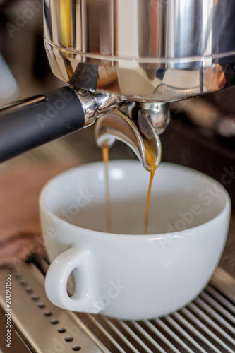 espresso flows from coffee machine