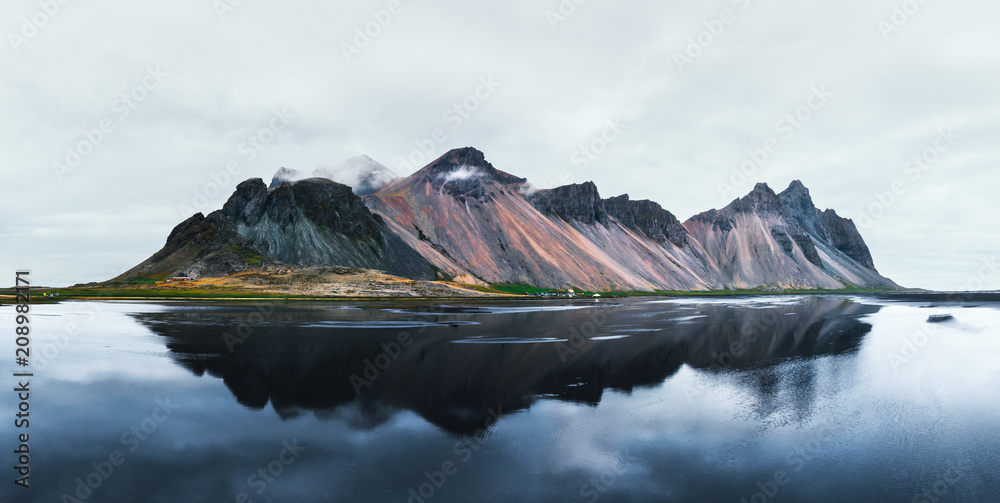 Fototapeta Famous Stokksnes mountains reflected in water on Vestrahorn cape, Iceland.