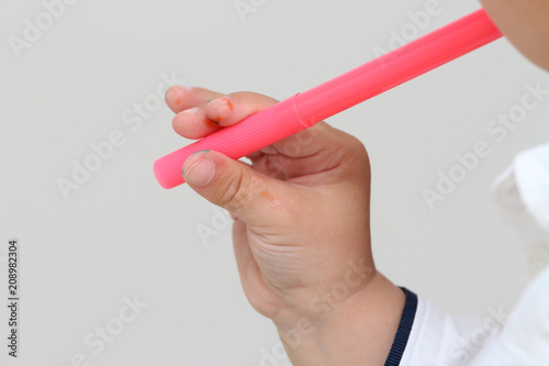 close up on the hand of a child who draws with colored markers