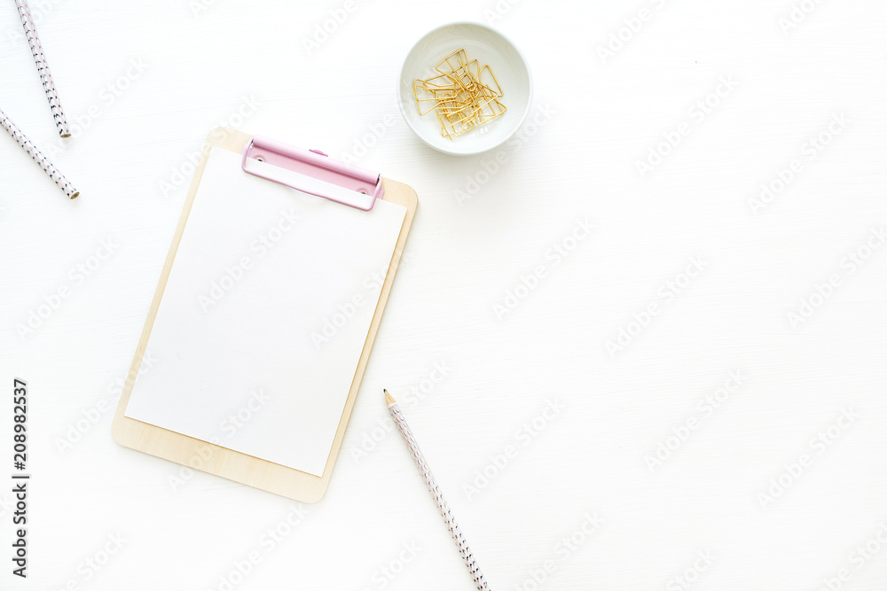 Flat lay home office desk workspace with clipboard on white background. Top view minimal mock up template. Flat lay home office desk workspace with clipboard on white background. Top view minimal mock up template.