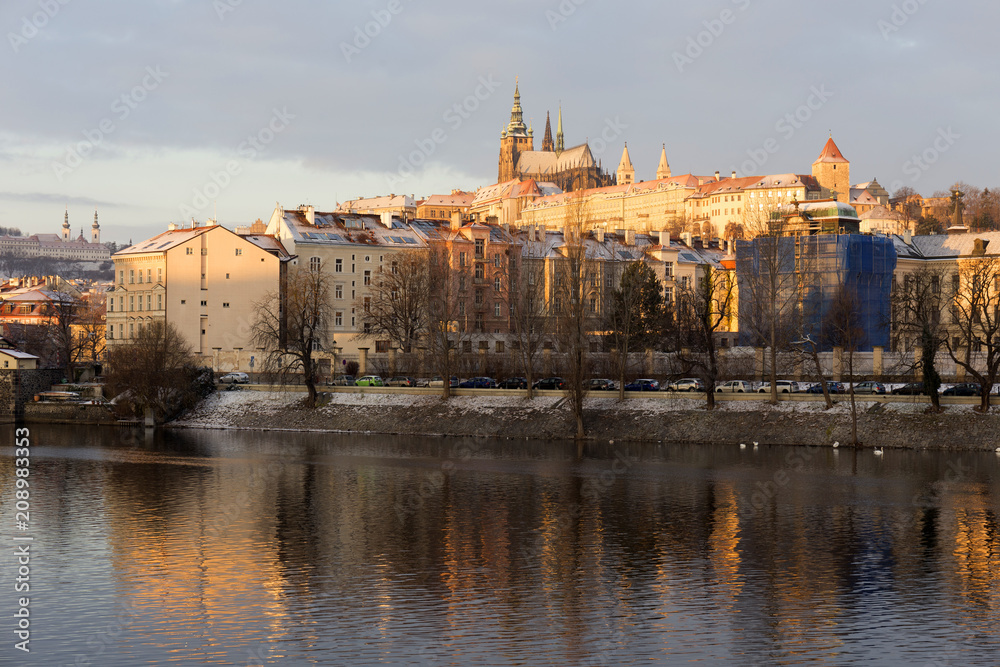 Obraz premium Sunny snowy early morning Prague Lesser Town with gothic Castle above River Vltava, Czech republic