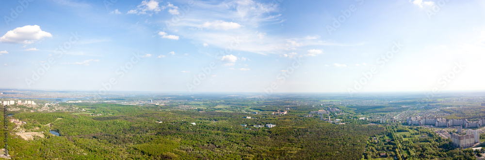 The panoramic bird's eye view shooting from drone to Holosiivskyi district with recreational area and urban infrastructure in Kiev, Ukraine at summer sunset.
