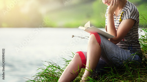 beautiful woman reading a book in the nature