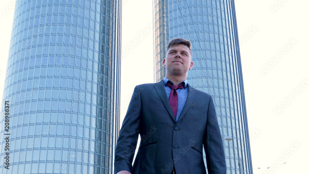 Young handsome businessman in suit, skyscraper background Young handsome businessman in suit, skyscraper background