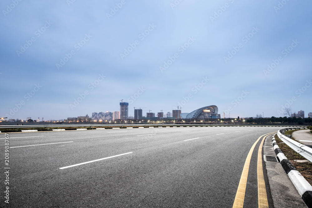 Fototapeta premium empty asphalt road with modern city skyline