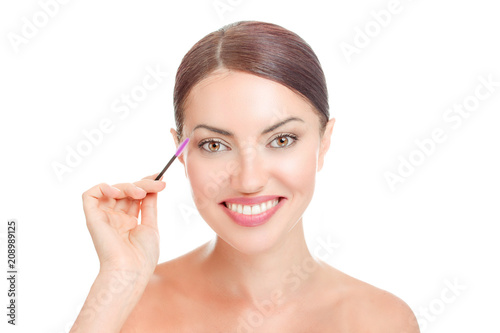 woman holding mascara brush near her long eyelashes