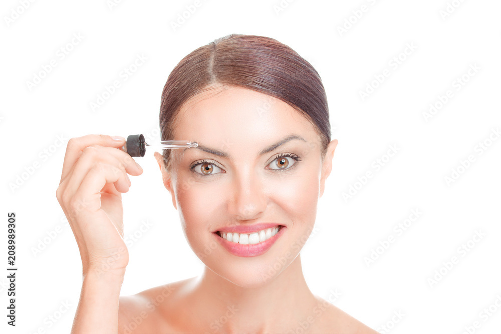 Woman applying serum essence essential oils to her eyebrows Woman applying serum essence essential oils to her eyebrows