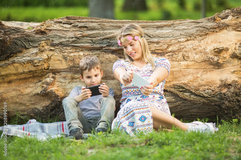 Fototapeta premium Mother and son in park playing video games