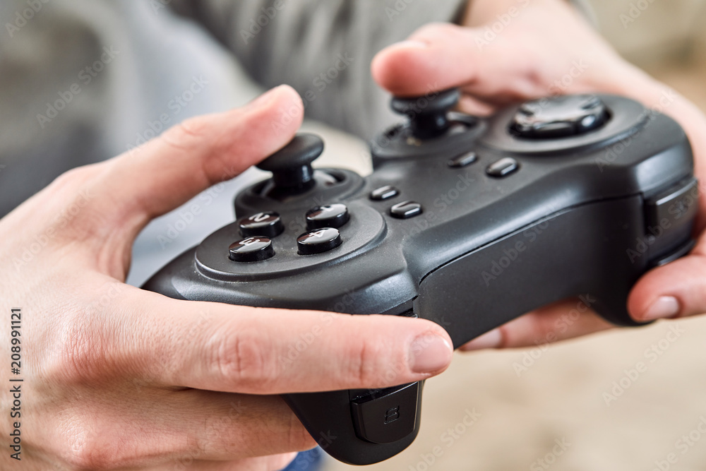 man holding a joystick controllers while playing a video games at home