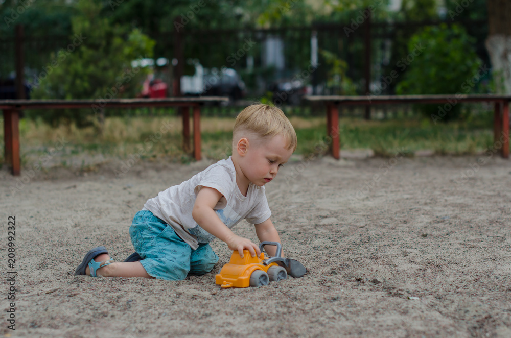 Cute little boy plays with a toy on the playground Cute little boy plays with a toy on the playground