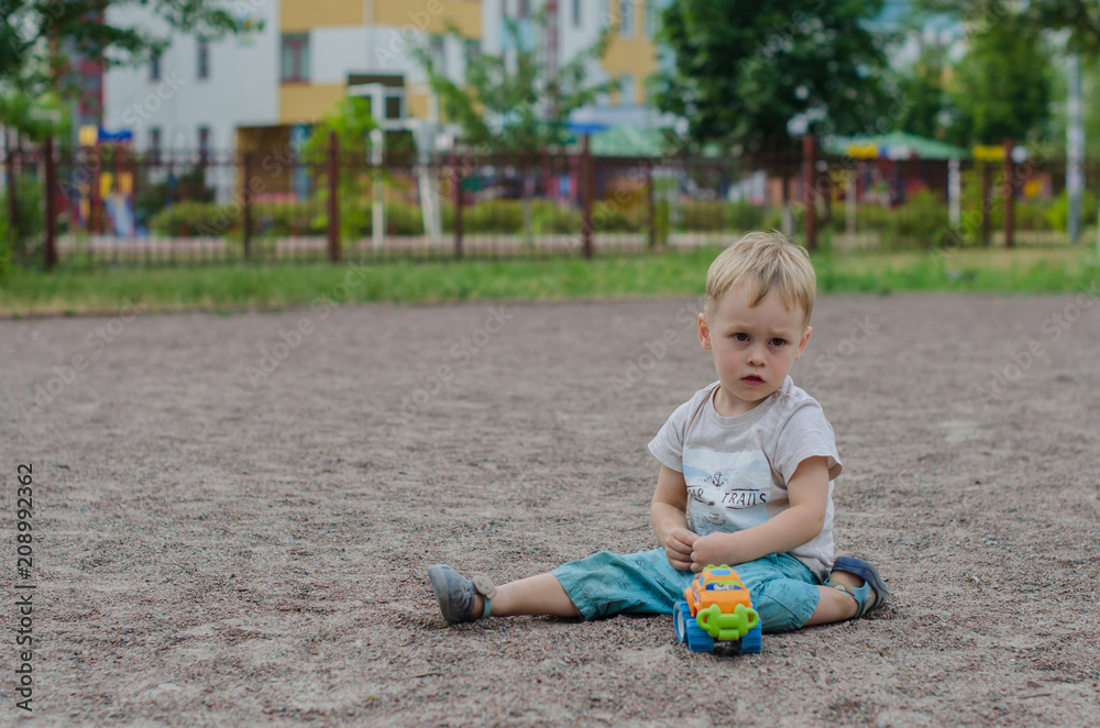 Cute little boy plays with a toy on the playground Cute little boy plays with a toy on the playground