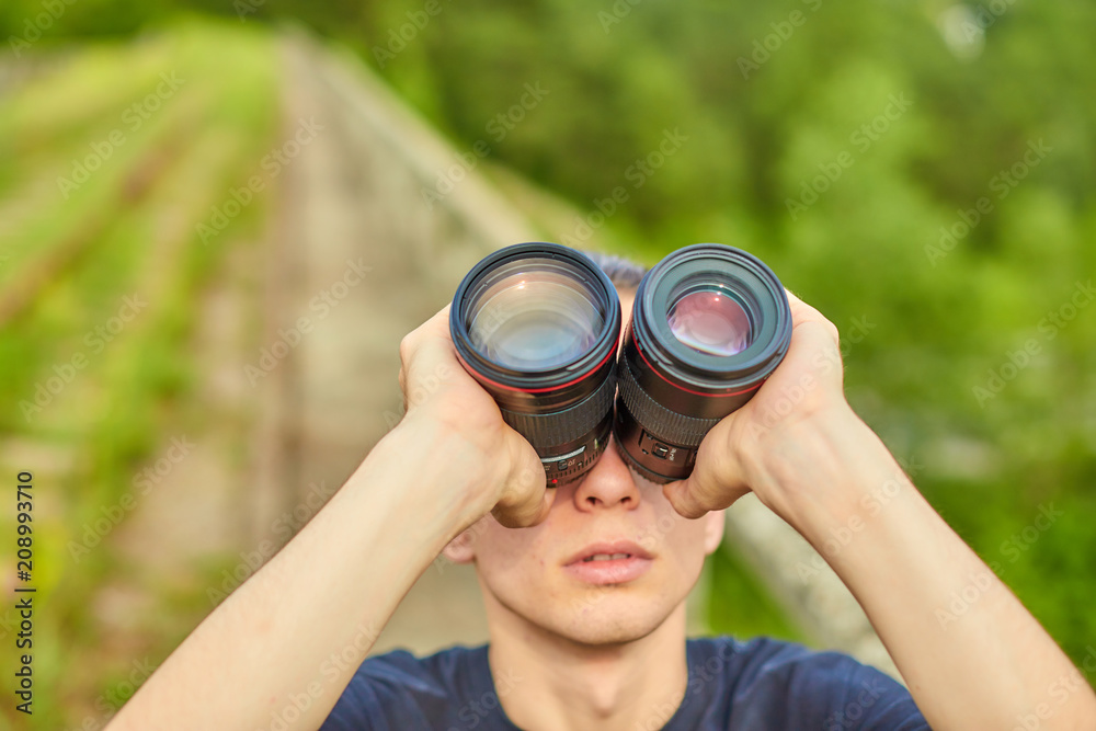 Young handsome man looking through lens Young handsome man looking through lens