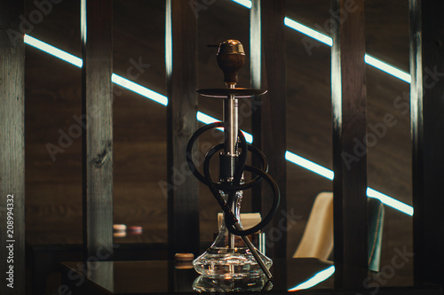 A beautiful glass hookah in a cafe on the table