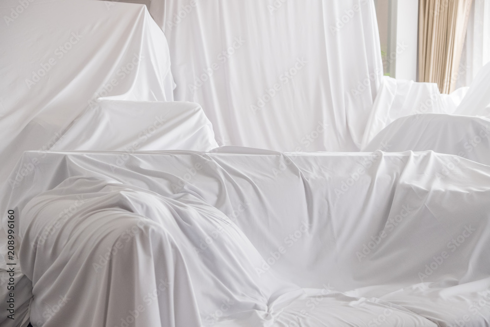 Obraz premium White dust cover cloth covering furnitures in a room