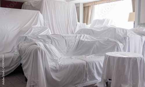 White dust cover cloth covering furnitures in a room photo