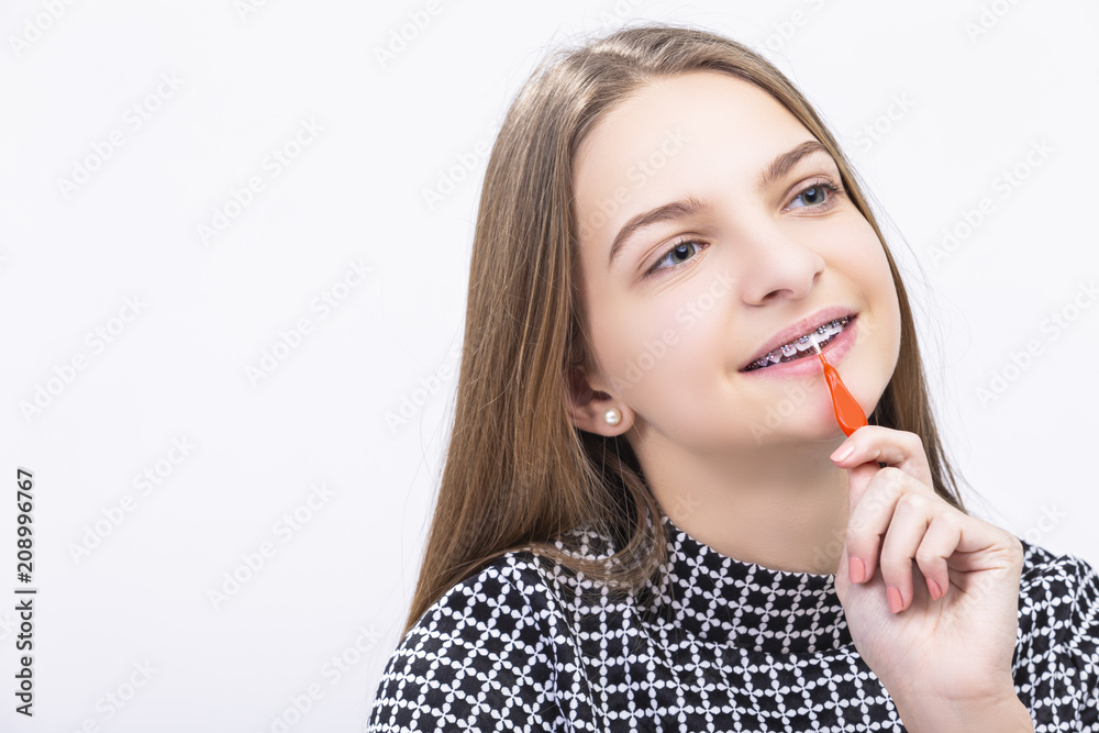 Medicine,Healthcare Ideas and Concepts. Closeup of Female Teenage Girl With Teeth Brackets Using Interdental Toothbrush for Cleaning Medicine,Healthcare Ideas and Concepts. Closeup of Female Teenage Girl With Teeth Brackets Using Interdental Toothbrush for Cleaning