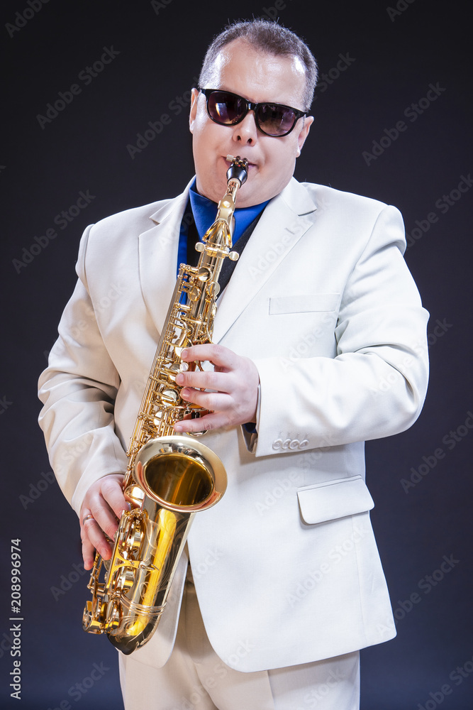 Fototapeta premium Music Themes and Ideas. Tranquil Caucasian Mature Saxophonist Against Black Background.