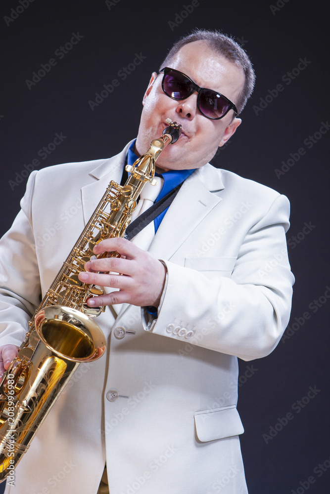 Fototapeta premium Portrait of Caucasian Expressive Mature Playing Saxophonist Against Black Background.