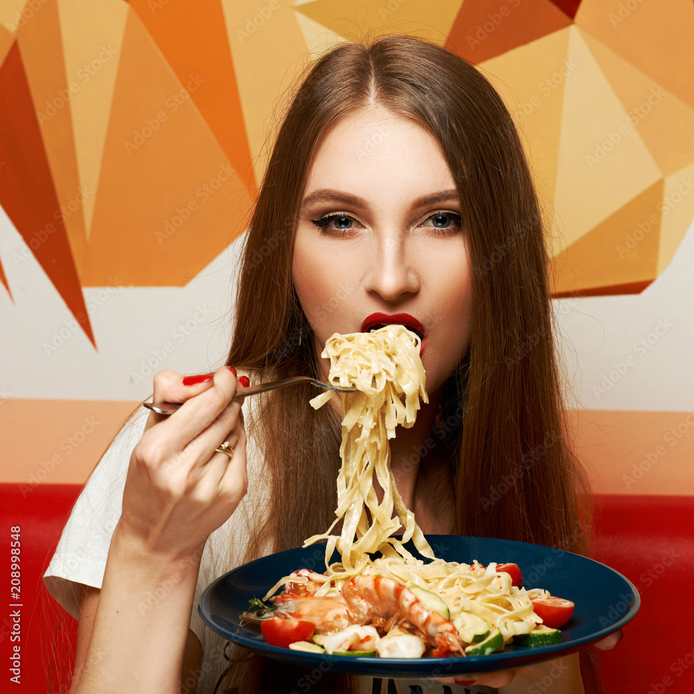 Portrait of attractive long haired woman with slightly ajar mouth and red lips eating Italian