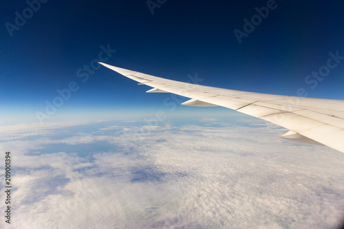 Wing of airplane with blue sky background.