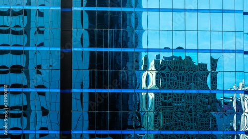 Blue sky and tower shadow reflected in the glass building.