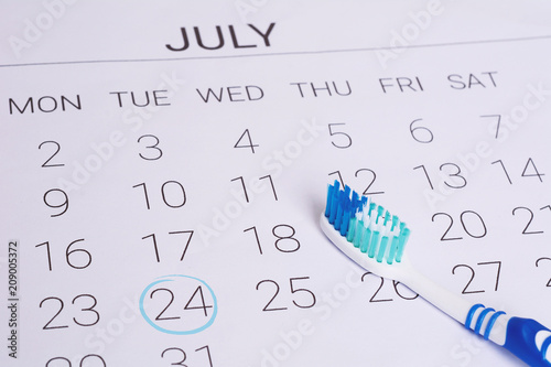 Calendar with a marked date and toothbrush.