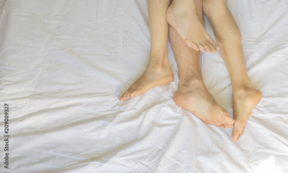 Feet of couple side by side in bed. Up view Feet of couple side by side in bed. Up view
