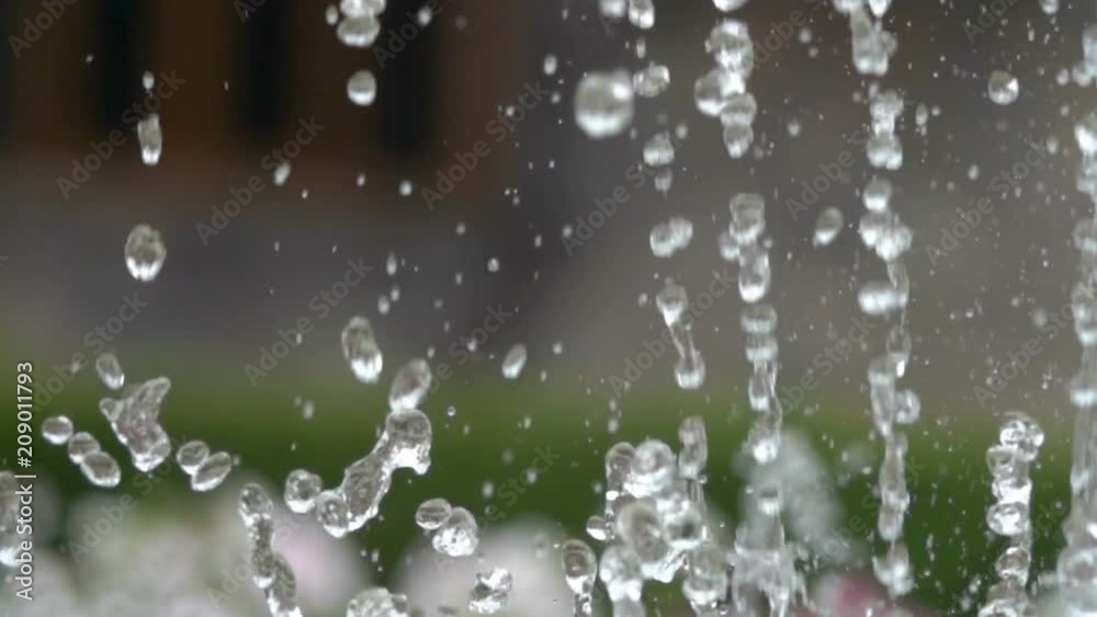 Closeup of light splashing water in sunny fountain in park in summer. Water fountain in garden. Slow motion. Closeup of light splashing water in sunny fountain in park in summer. Water fountain in garden. Slow motion.
