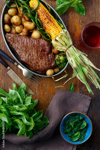 Beef steak fried corn vegetables top view Dinner table photo