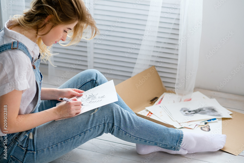 Naklejka premium creative art lifestyle. drawing hobby and self expression. young beautiful girl painting a picture at home