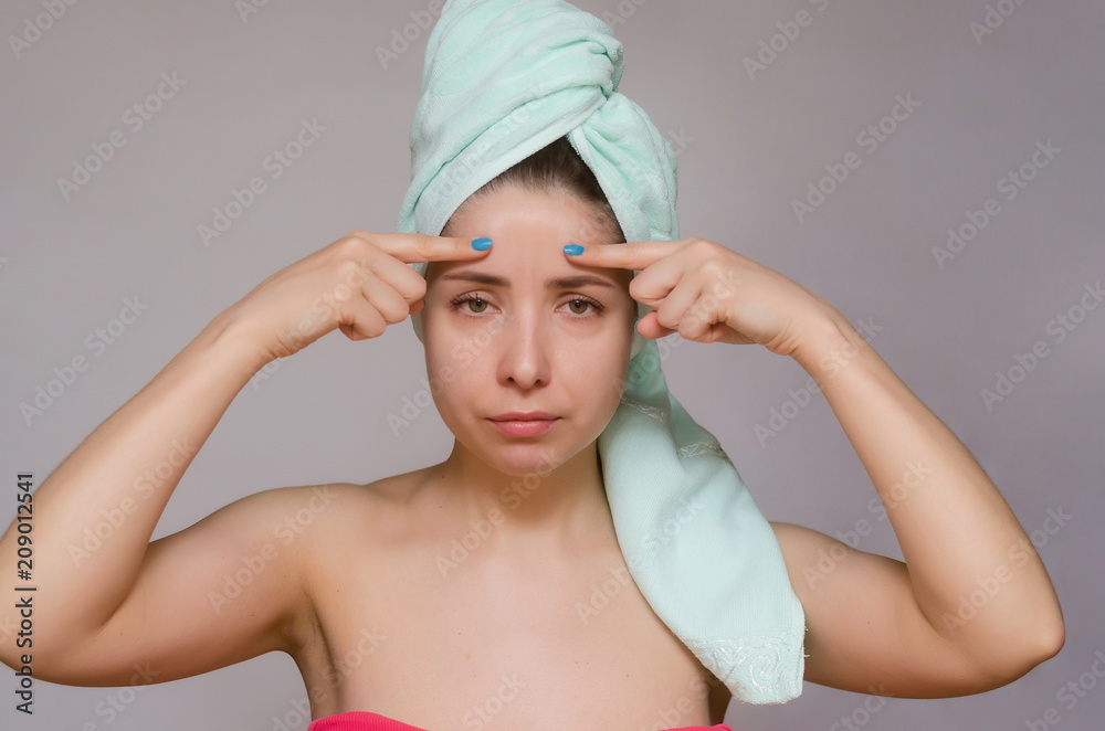 Woman makes skin massage with fingers isolated on gray background. Face skin care treatment concept. Woman makes skin massage with fingers isolated on gray background. Face skin care treatment concept.
