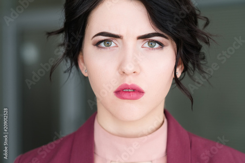emotion face. sad upset serious woman with sullen look. young beautiful brunette girl portrait