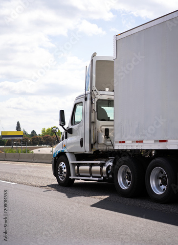 Big rig semi truck with day cab for local delivery transporting semi trailer on the road