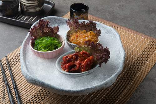 Japanese seasoned baby octopus, seaweed and jellyfish on shaved ice photo