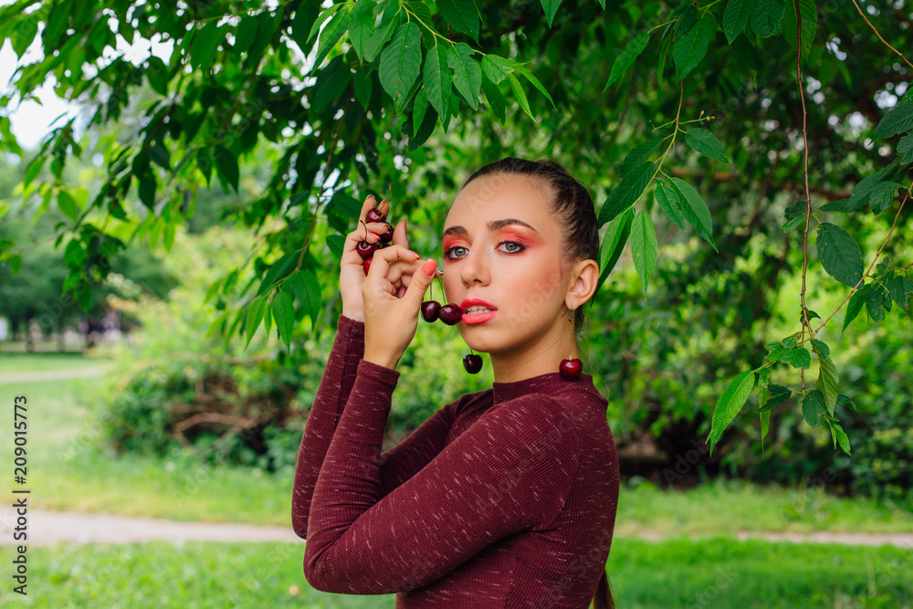 Beautiful young woman with long braid and natural cherry earrings. Beautiful young woman with long braid and natural cherry earrings.