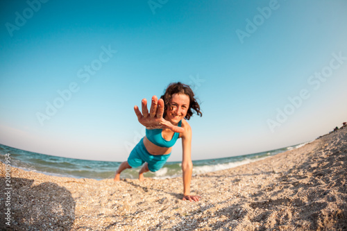 The girl wriggles out on the beach. © zhukovvvlad