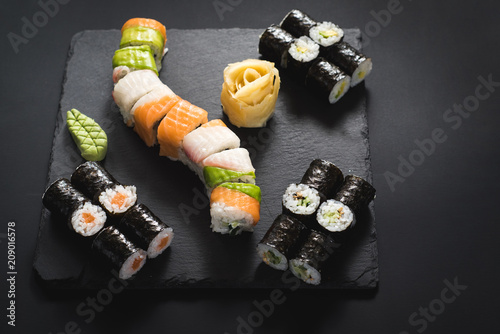 A set of different sushi rolls with caviar on black background © rostyslav84