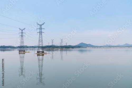 power transmission tower and reflection on lake
