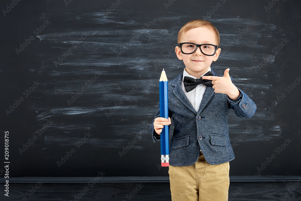 Little boy against blackboard. School concept