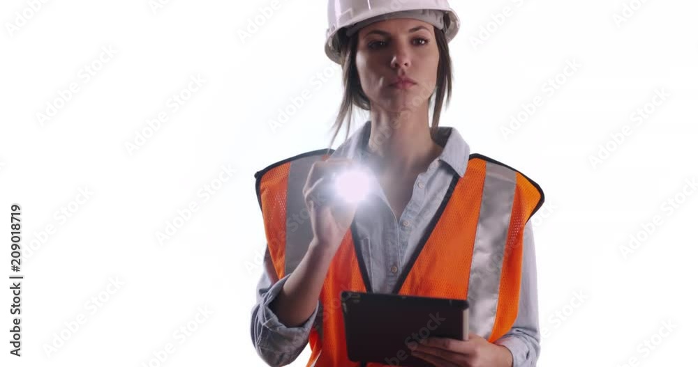 Woman worker in safety gear with tablet and flashlight on solid white copy space, Female engineer working shining flashlight at camera on white background, 4k Woman worker in safety gear with tablet and flashlight on solid white copy space, Female engineer working shining flashlight at camera on white background, 4k