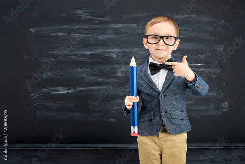 Obraz na płótnie Little boy against blackboard. School concept w salonie