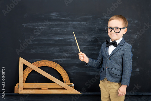 Obraz na płótnie Little boy against blackboard. School concept w salonie