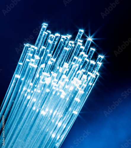 Bundle of optical fibers with lights in the ends. Blue background. photo